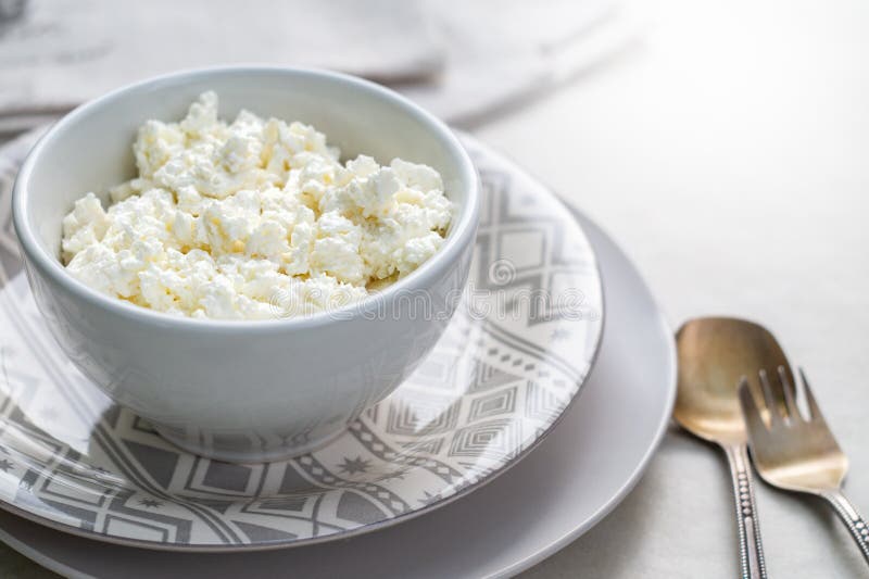 Cottage Cheese On A White Bowl On A Gray Background Stock Photo