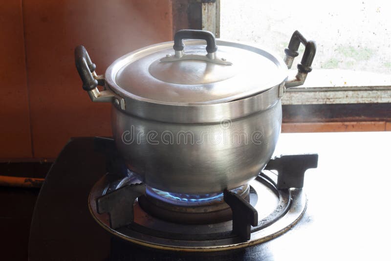 Cottura con pentola di alluminio sul forno a gas in cucina fotografia stock Cottura con pentola di alluminio sul forno a gas in cucina fotografia stock