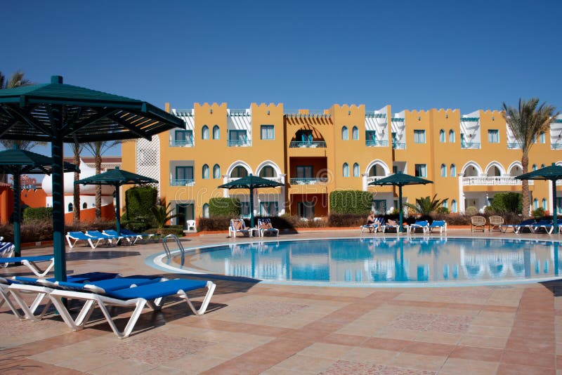 Couch and sunshade near of swimming pool