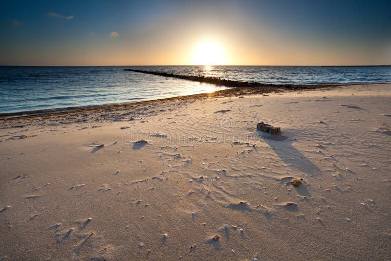 Coucher du soleil chaud au-dessus de plage de sable sur la Mer du Nord photographie stock Coucher du soleil chaud au-dessus de plage de sable sur la Mer du Nord photographie stock