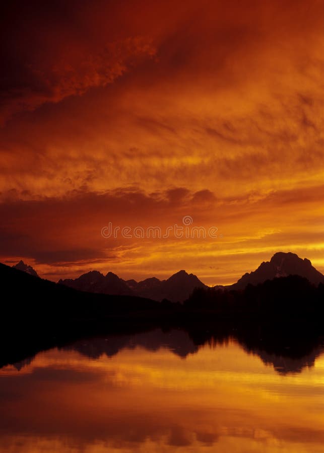 Sunsets behing the Teton mountains and is reflected in the Snake River. Sunsets behing the Teton mountains and is reflected in the Snake River