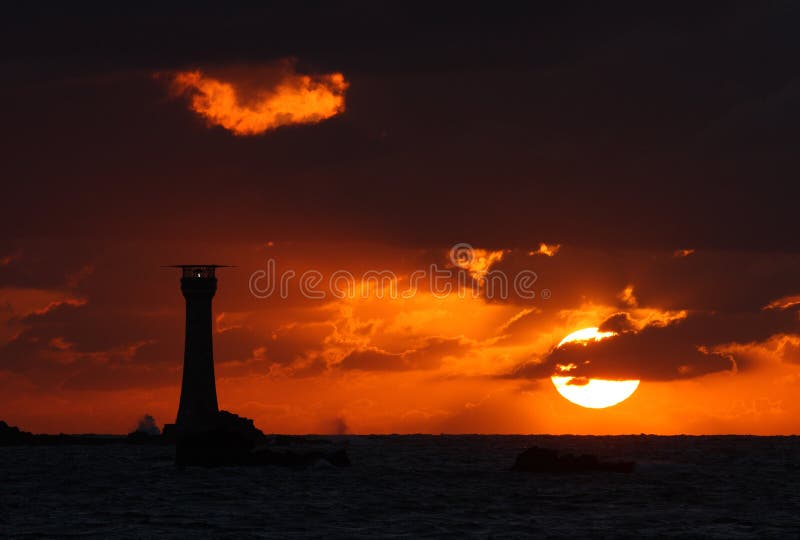 Coucher du soleil de Guernesey derrière le phare de Hanois photos libres de droits Coucher du soleil de Guernesey derrière le phare de Hanois photos libres de droits
