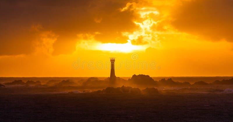 Coucher du soleil de Guernesey derrière le phare de Hanois image libre de droits Coucher du soleil de Guernesey derrière le phare de Hanois image libre de droits
