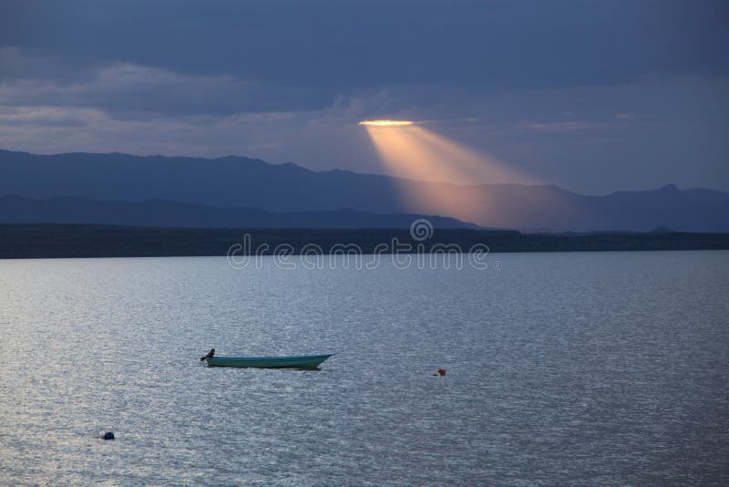 Sunset through the clouds over a lake. Sunset through the clouds over a lake