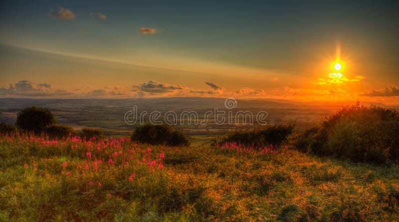Sunset in Somerset England UK view from Quantocks Hills to Blackdown Hills across Taunton valley in vivid colourful HDR like a painting. Sunset in Somerset England UK view from Quantocks Hills to Blackdown Hills across Taunton valley in vivid colourful HDR like a painting
