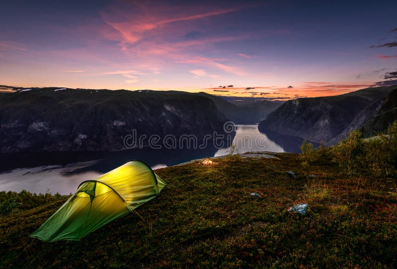 Coucher du soleil et tente en automne dans Aurlandsfjord, Norvège photo libre de droits Coucher du soleil et tente en automne dans Aurlandsfjord, Norvège photo libre de droits