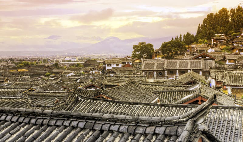 Colors of sunset reflect off the ancient rooftops of the old town of Lijiang in northern Yunnan province in China. Colors of sunset reflect off the ancient rooftops of the old town of Lijiang in northern Yunnan province in China.