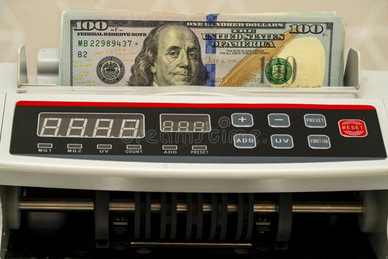 Currency counting machine shows hundred dollar bill in use stock photos