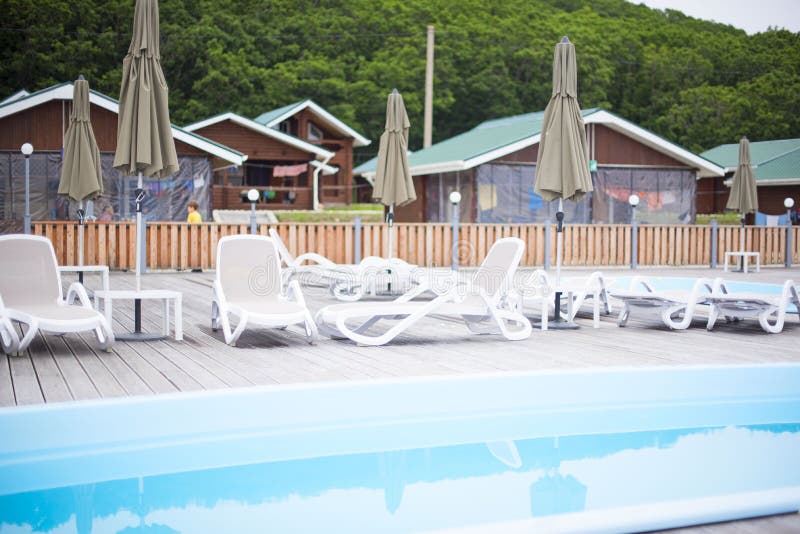 Country club recreation recreation relax pool wooden house forest trees sun lounger umbrella. stock image Country club recreation recreation relax pool wooden house forest trees sun lounger umbrella. stock image