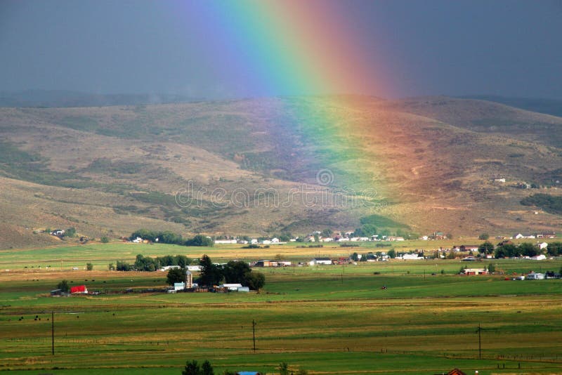 Country farm, field and rainbow