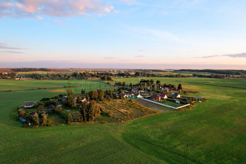 Country houses in the countryside. Aerial view of roofs of green field with rural homes. Village with wooden home. Suburban house