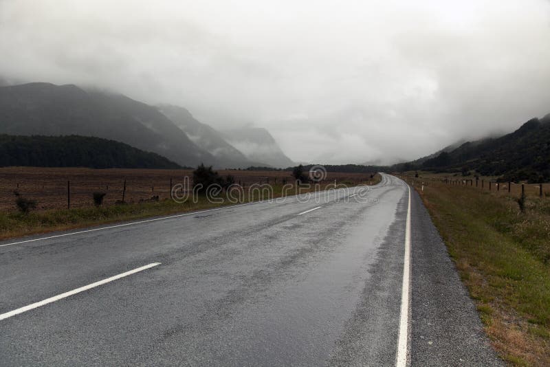 Country mountain road in rain and clouds