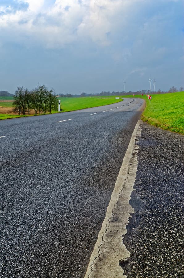 Country road under cloudy blue sky. Close-up view of a country road and green meadow under cloudy blue sky royalty free stock images Country road under cloudy blue sky. Close-up view of a country road and green meadow under cloudy blue sky royalty free stock images