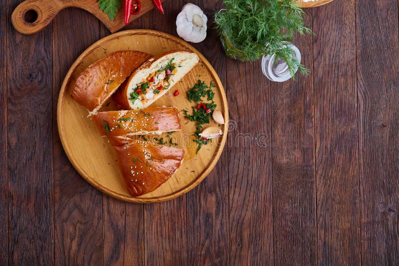 Countryside cuisine still life with pie, vegetable and herbs on cutting board over white background, selective focus.