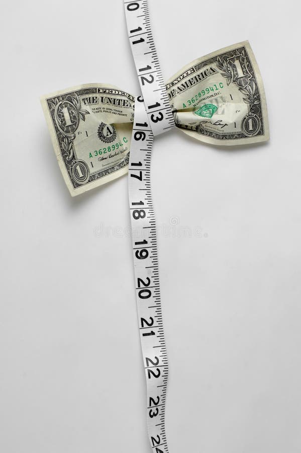 Dollar bill being squeezed by tape measure on white background. Dollar bill being squeezed by tape measure on white background.