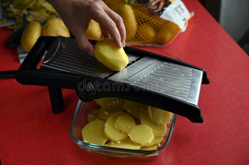 Coupant Des Pommes De Terre Avec De La Mandoline De Cuisine Photo