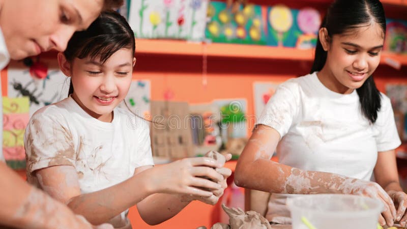 Coupe d'argile de modélisation de fille en regardant un garçon intelligent en classe d'art. Édification banque de vidéos
