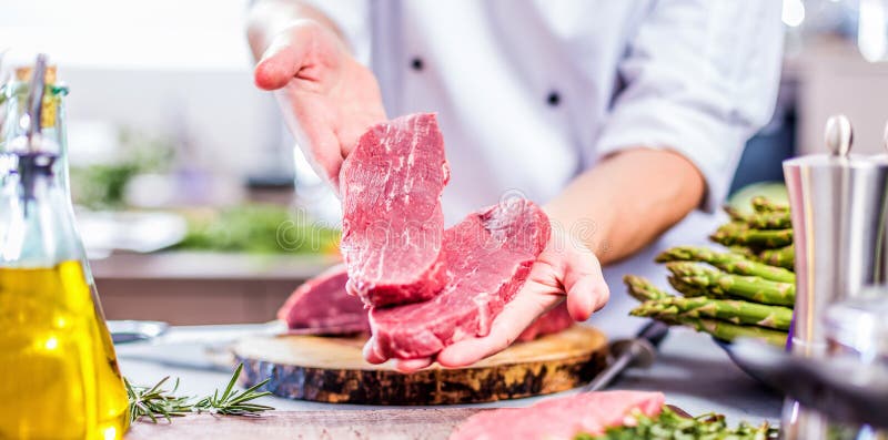 Coupe de chef et viande de cuisson dans la cuisine de restaurant photographie stock libre de droits Coupe de chef et viande de cuisson dans la cuisine de restaurant photographie stock libre de droits