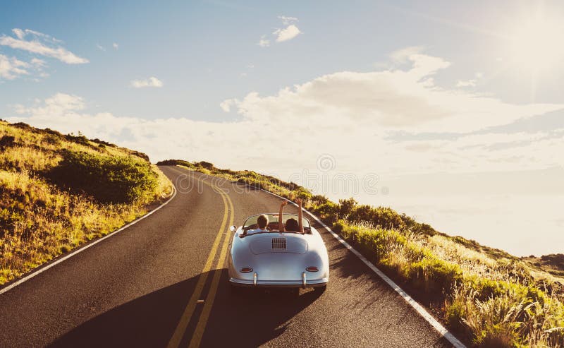 Happy Couple Driving on Country Road in Classic Vintage Sports Car. Happy Couple Driving on Country Road in Classic Vintage Sports Car