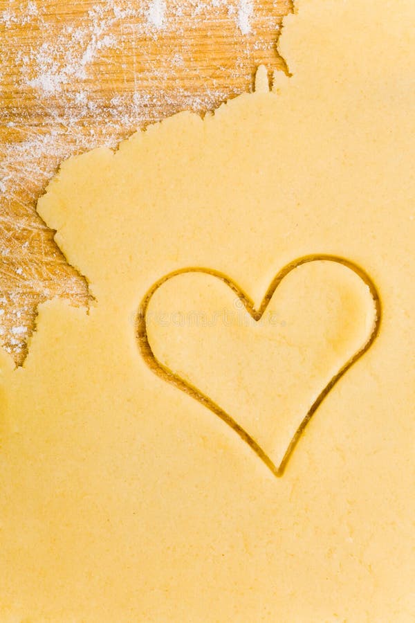Coupeur en forme de coeur de biscuit sur la pâte photographie stock libre de droits Coupeur en forme de coeur de biscuit sur la pâte photographie stock libre de droits