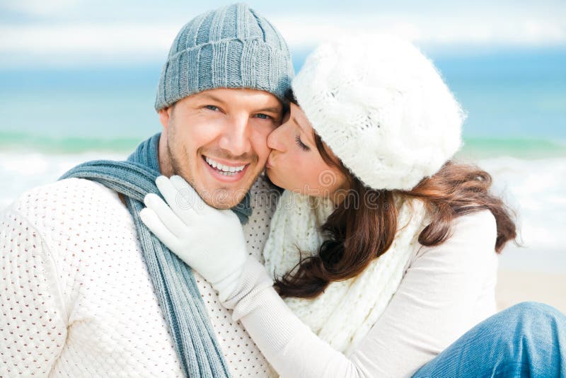 Loving coast couple with warm clothes embracing eachother in colder season time