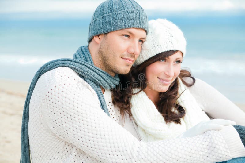 Winter couple sitting on blue sea