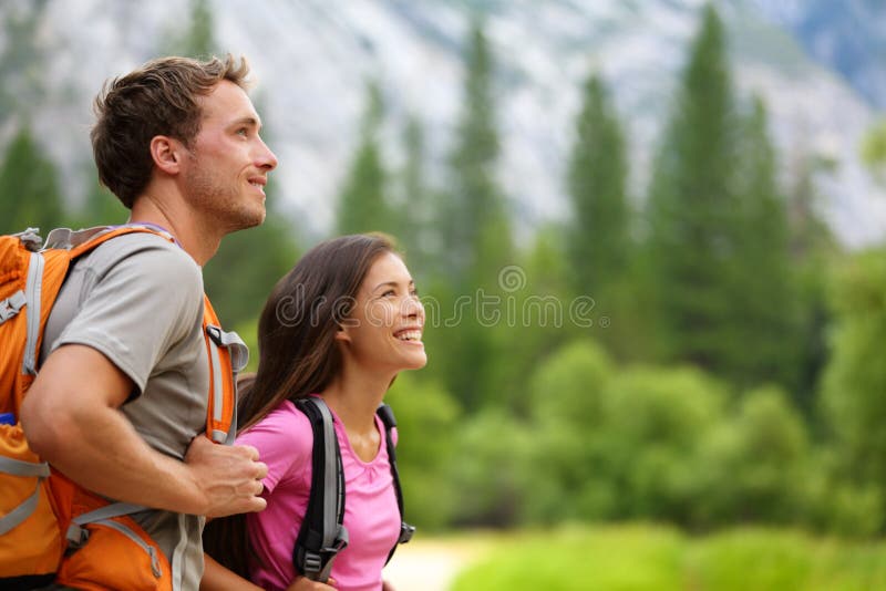 Couple - active hikers hiking in Yosemite. Couple - active hikers hiking enjoying view looking at mountain forest landscape in Yosemite National Park, California stock images