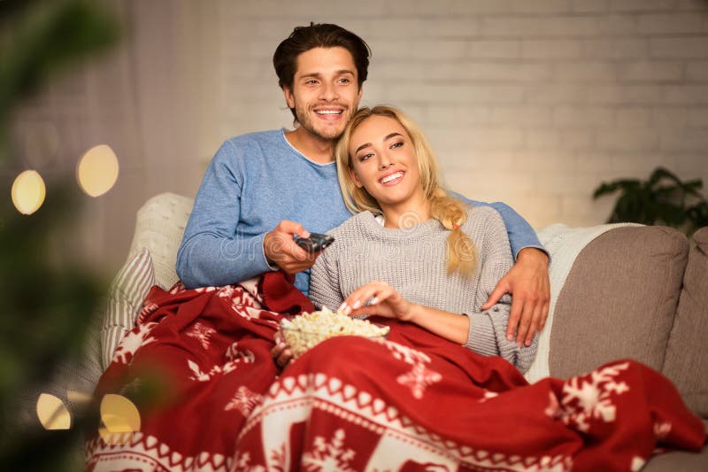 Couple amoureux à noël veille déguster du pop-corn image libre de droits