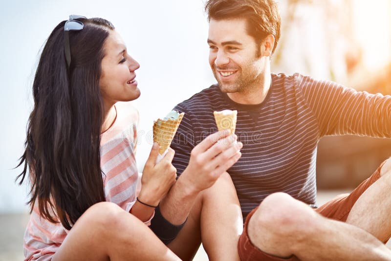 Couple at amusement park sharing ice cream