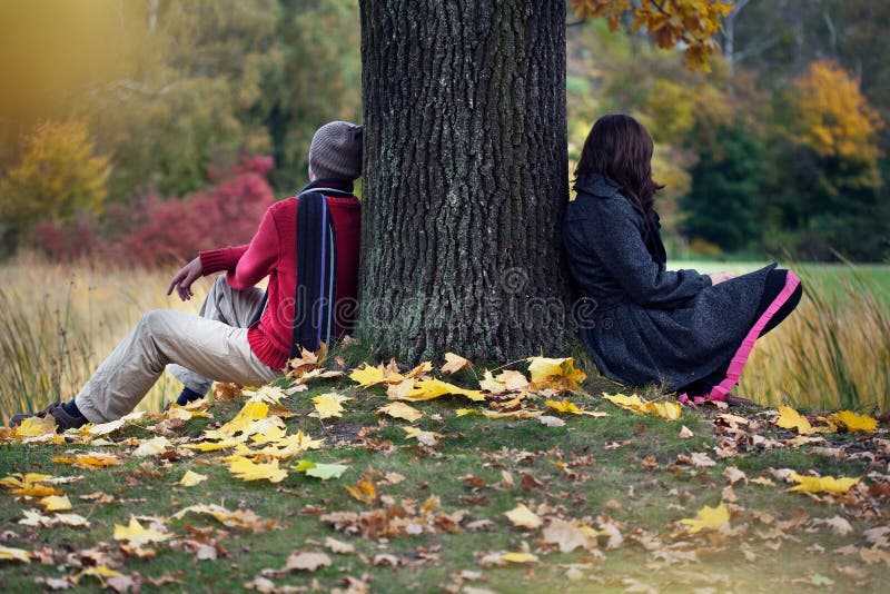 Couple after arguing sitting in autumn park