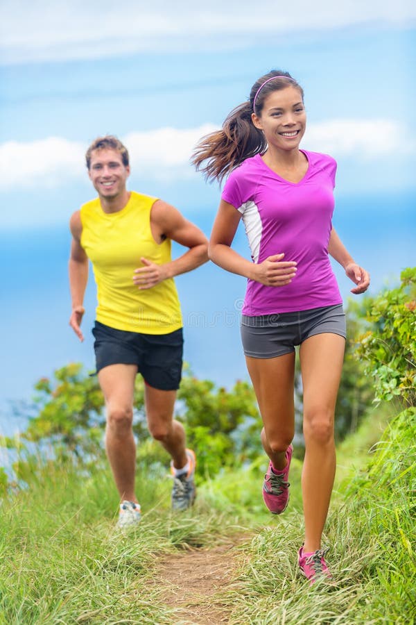 Couple athletes trail running together in nature