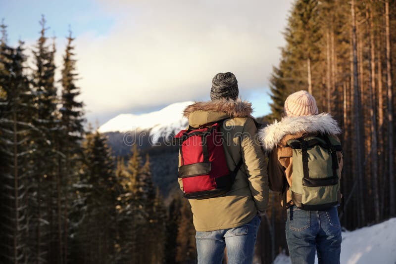 Couple With Backpacks Enjoying Mountain View During Winter