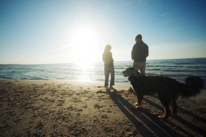 Glückliches paar mit Hund am Strand.