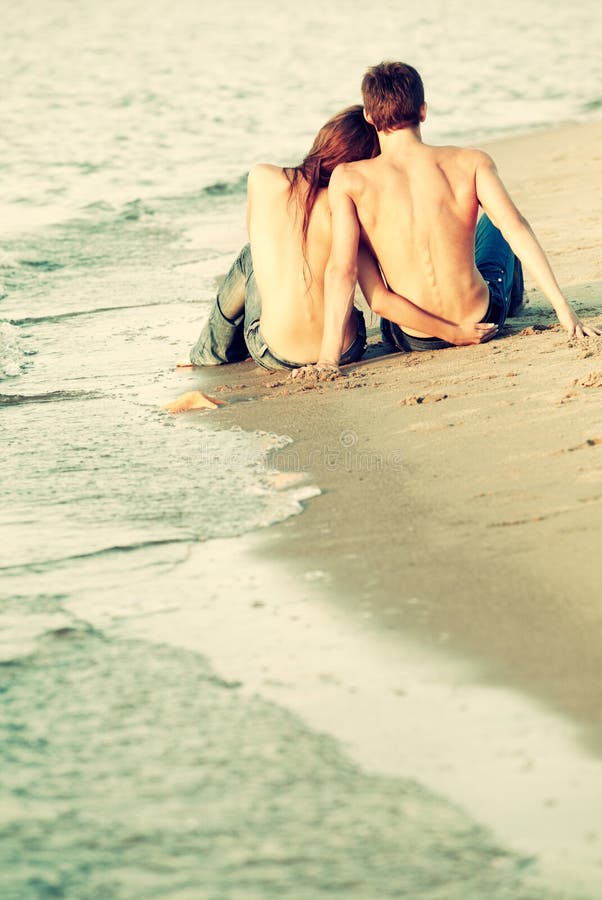 Topless ladies surrounded by dressed men at the beach