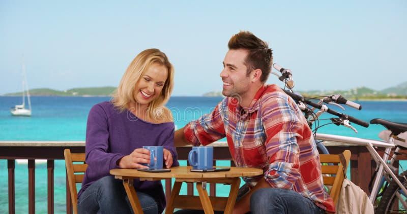 Couple blanc millénaire assis dans un joli café près de la plage en buvant du café