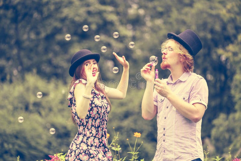 Couple blowing bubbles outdoor stock photos