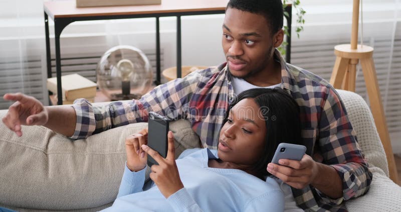 Couple browsing social media using mobile phones at home