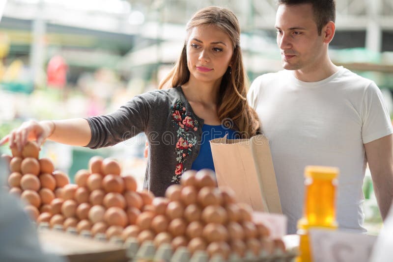 Couple buying fresh eggs at farmerâ€™s market