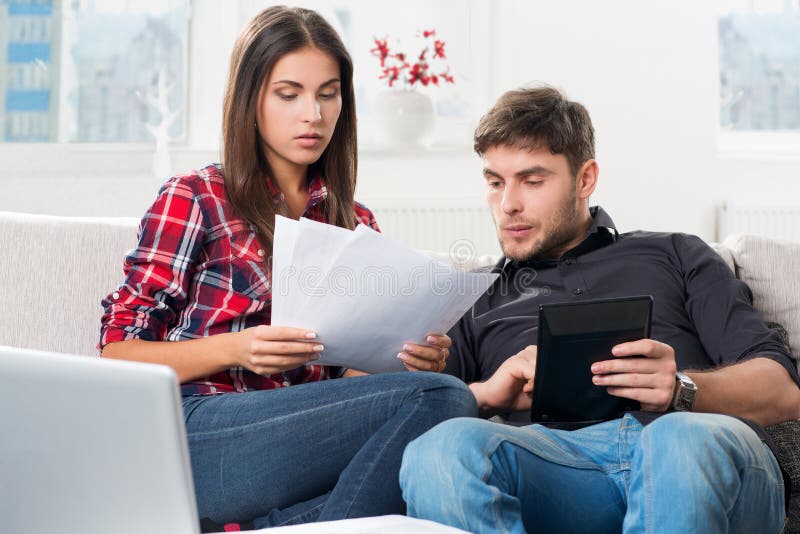 Couple calculating their domestic bills at home royalty free stock images Couple calculating their domestic bills at home royalty free stock images