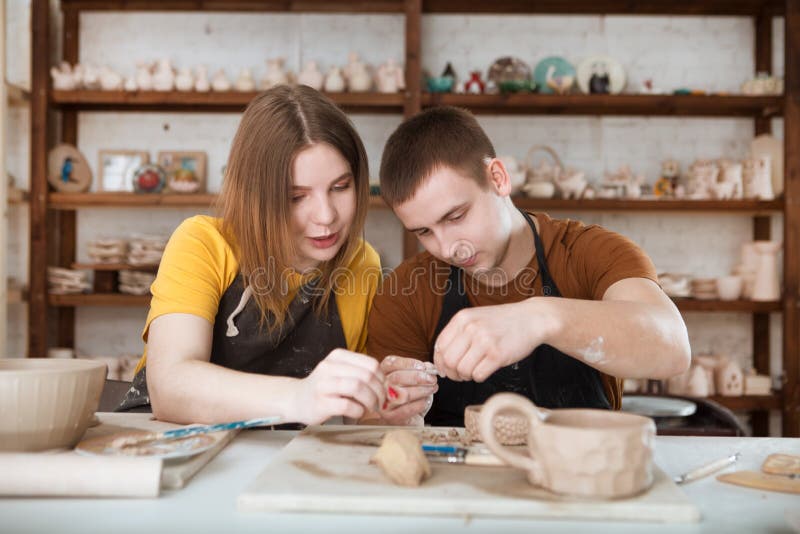 Couple in Casual Clothes and Aprons Making Ceramic Pot on Pottery at Table in Stock