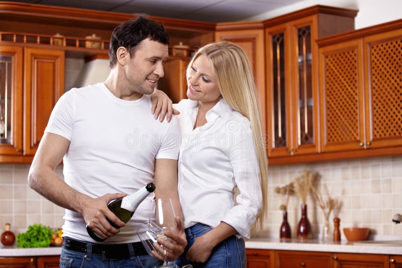 Couple with champagne on kitchen