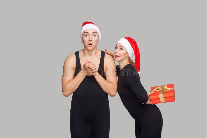 Couple in christmas hat. Shocked man looking at camera. woman ho stock photos Couple in christmas hat. Shocked man looking at camera. woman ho stock photos