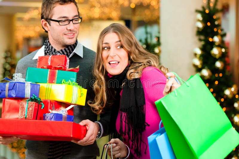 Couple with Christmas presents and bags in mall