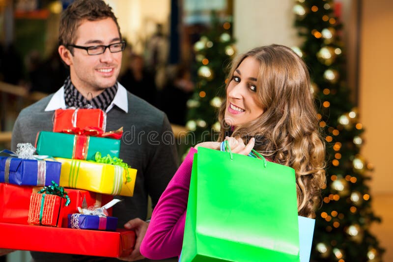 Couple with Christmas presents and bags in shoppin