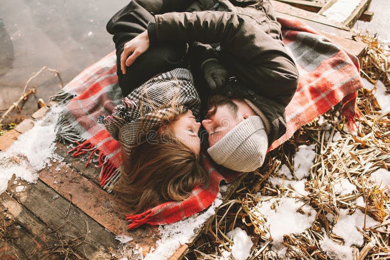 Couple close lying on plaid in winter park