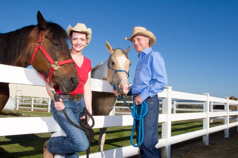 Couple in Cowboy Hats With Horses - Horizontal