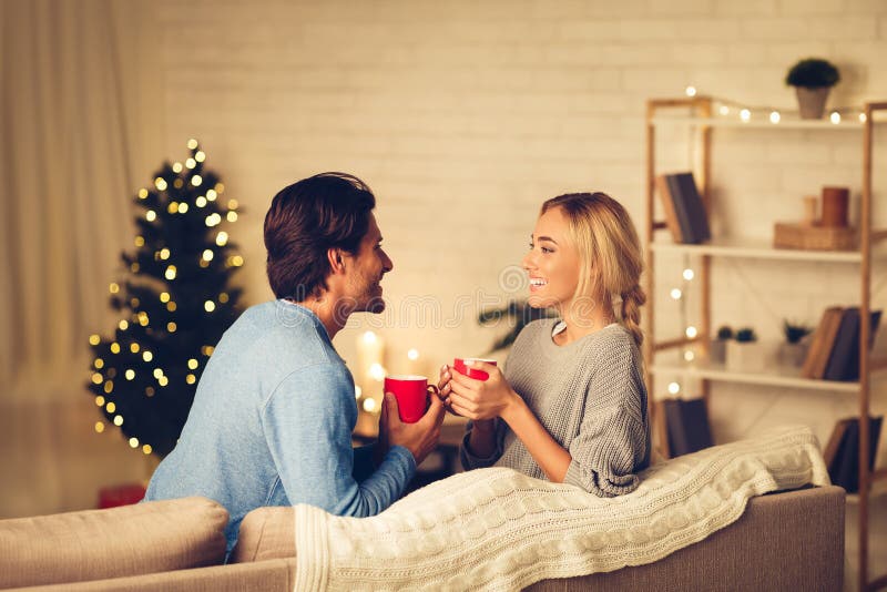 Couple célébrant noël à la maison se relaxer avec des tasses de café photo stock