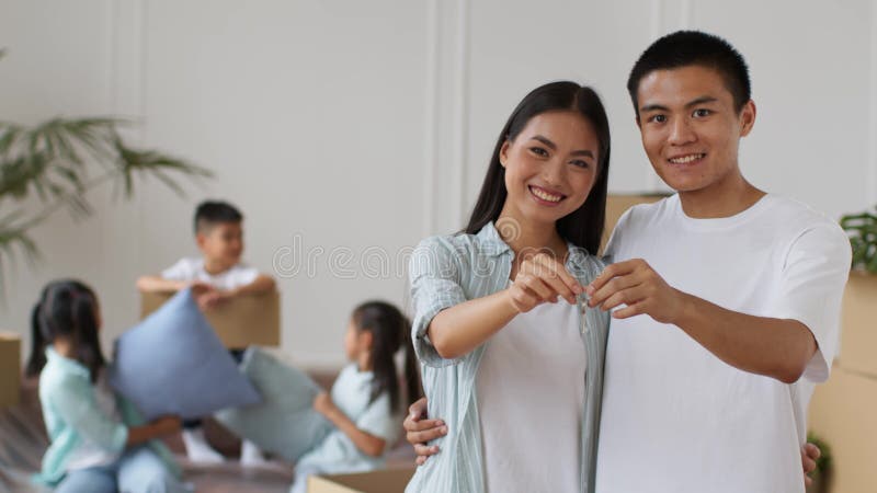 Couple d'asiatiques heureux montrant une nouvelle clé d'accueil étreinte à l'intérieur clips vidéos