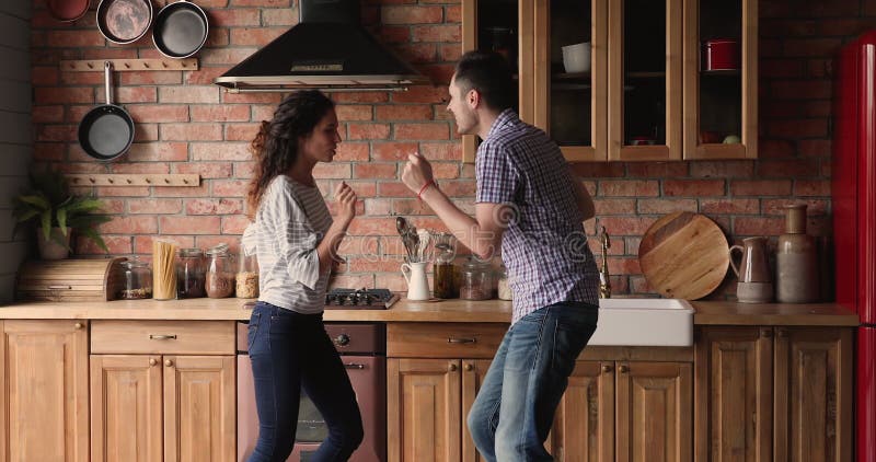 Couple dancing in kitchen celebrate moving day to new home