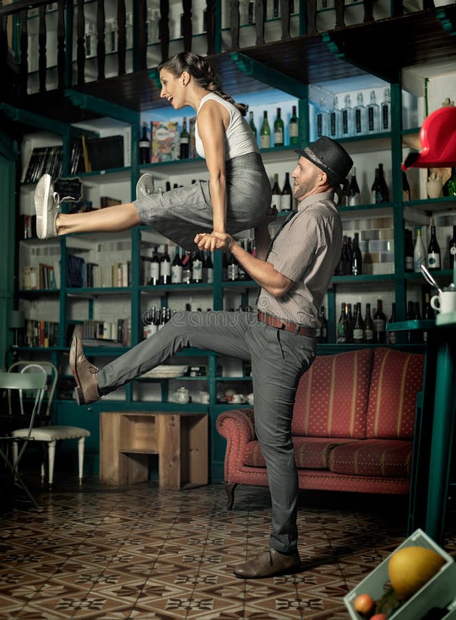 Couple dancing and jumping in a vintage coffee room
